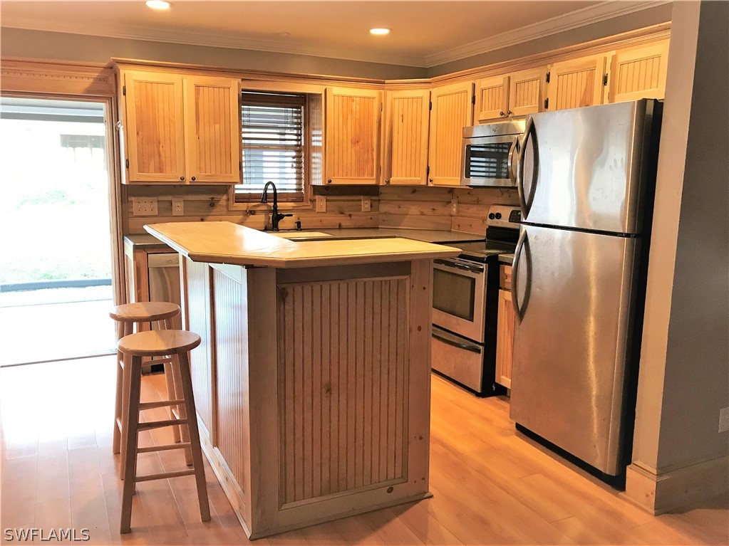 18449 Flamingo Road Fort Myers, FL 33967 - Photo 7 of 20 a kitchen with stainless steel appliances granite countertop a refrigerator a sink and a stove