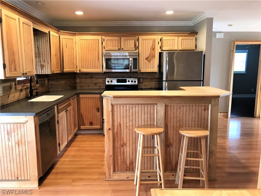 18449 Flamingo Road Fort Myers, FL 33967 - Photo 8 of 20 a kitchen with stainless steel appliances granite countertop a sink and a refrigerator