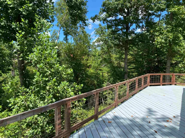 a view of balcony with wooden floor and fence