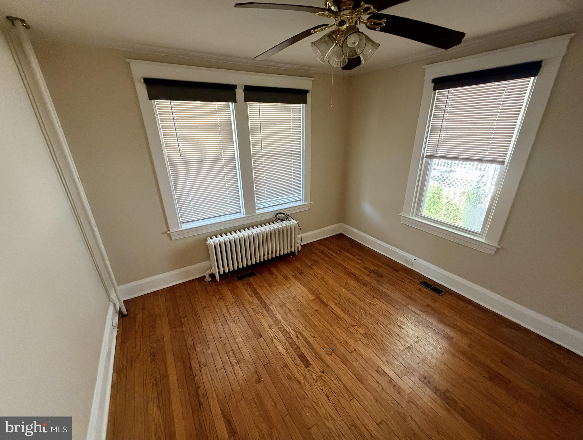 506 Cedarcroft Road Baltimore, MD 21212 - Photo 6 of 16 a view of an empty room with wooden floor and a window