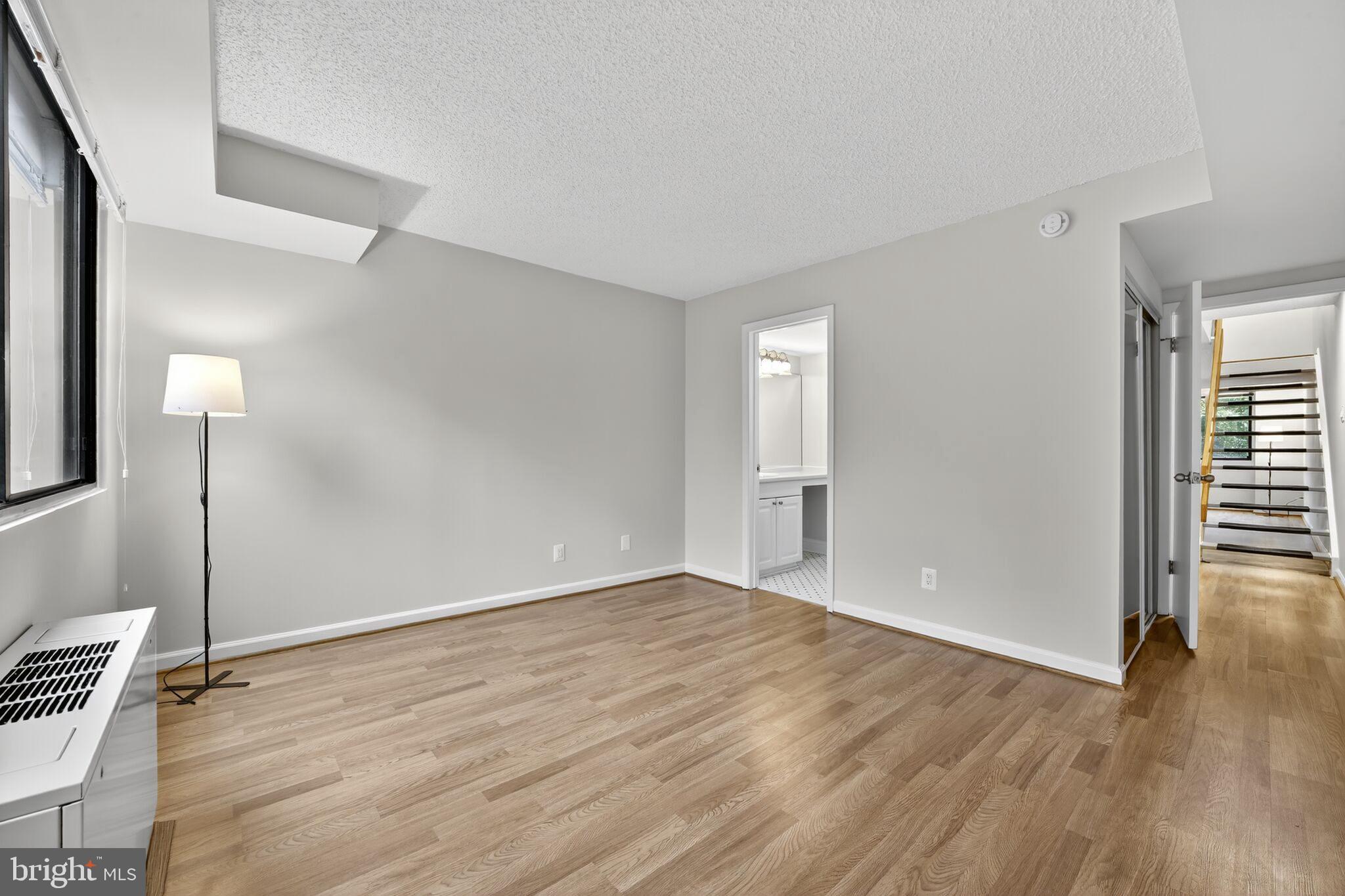 1245 13th Street Northwest, Unit 304 Washington, DC 20005 - Photo 12 of 43 an empty room with wooden floor and windows