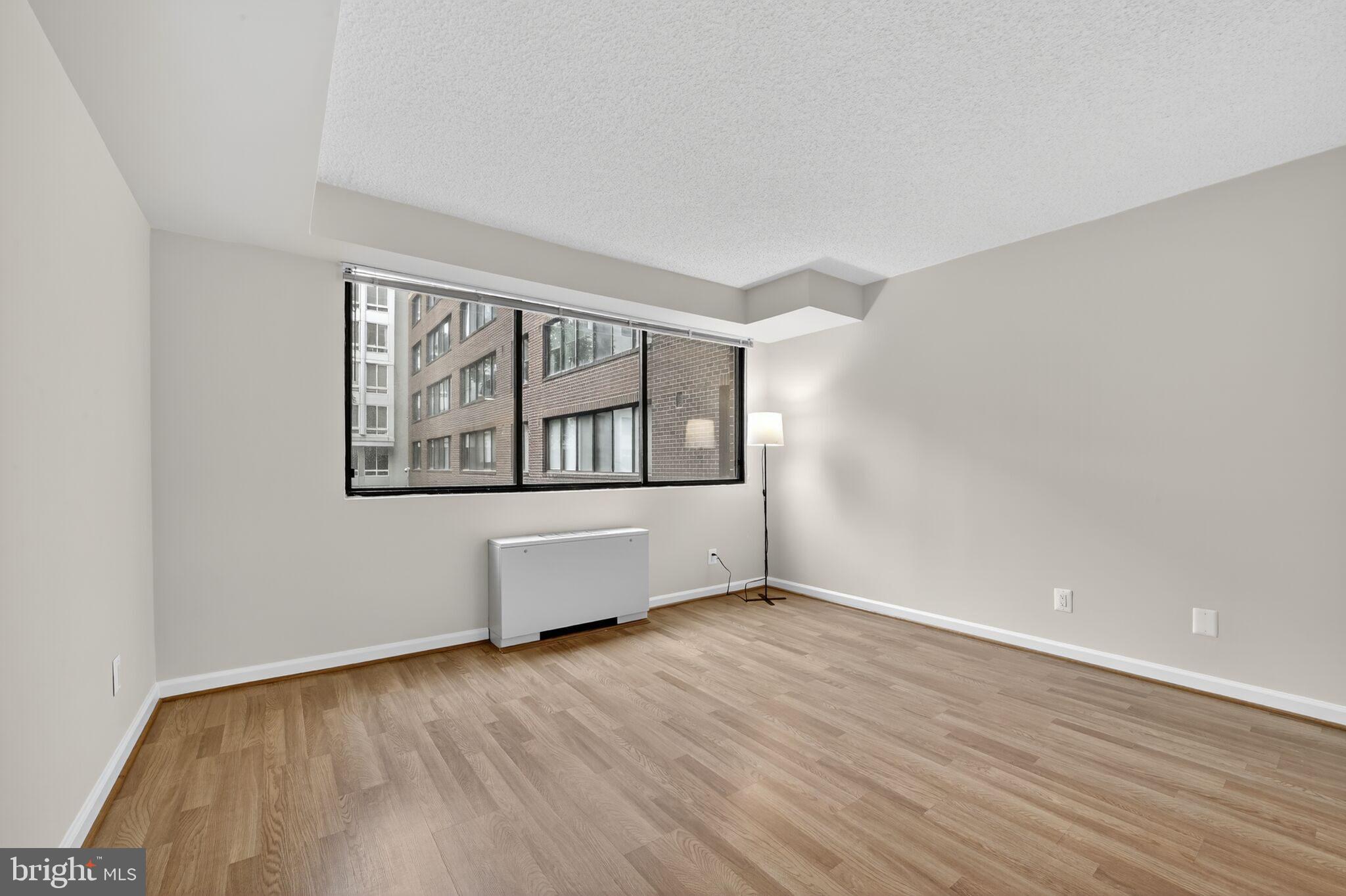 1245 13th Street Northwest, Unit 304 Washington, DC 20005 - Photo 13 of 43 a view of an empty room with wooden floor and a window