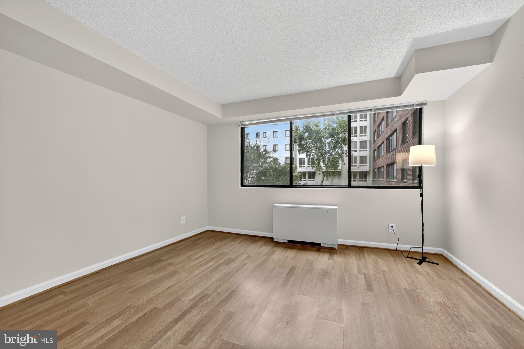 1245 13th Street Northwest, Unit 304 Washington, DC 20005 - Photo 14 of 43 an empty room with wooden floor and windows