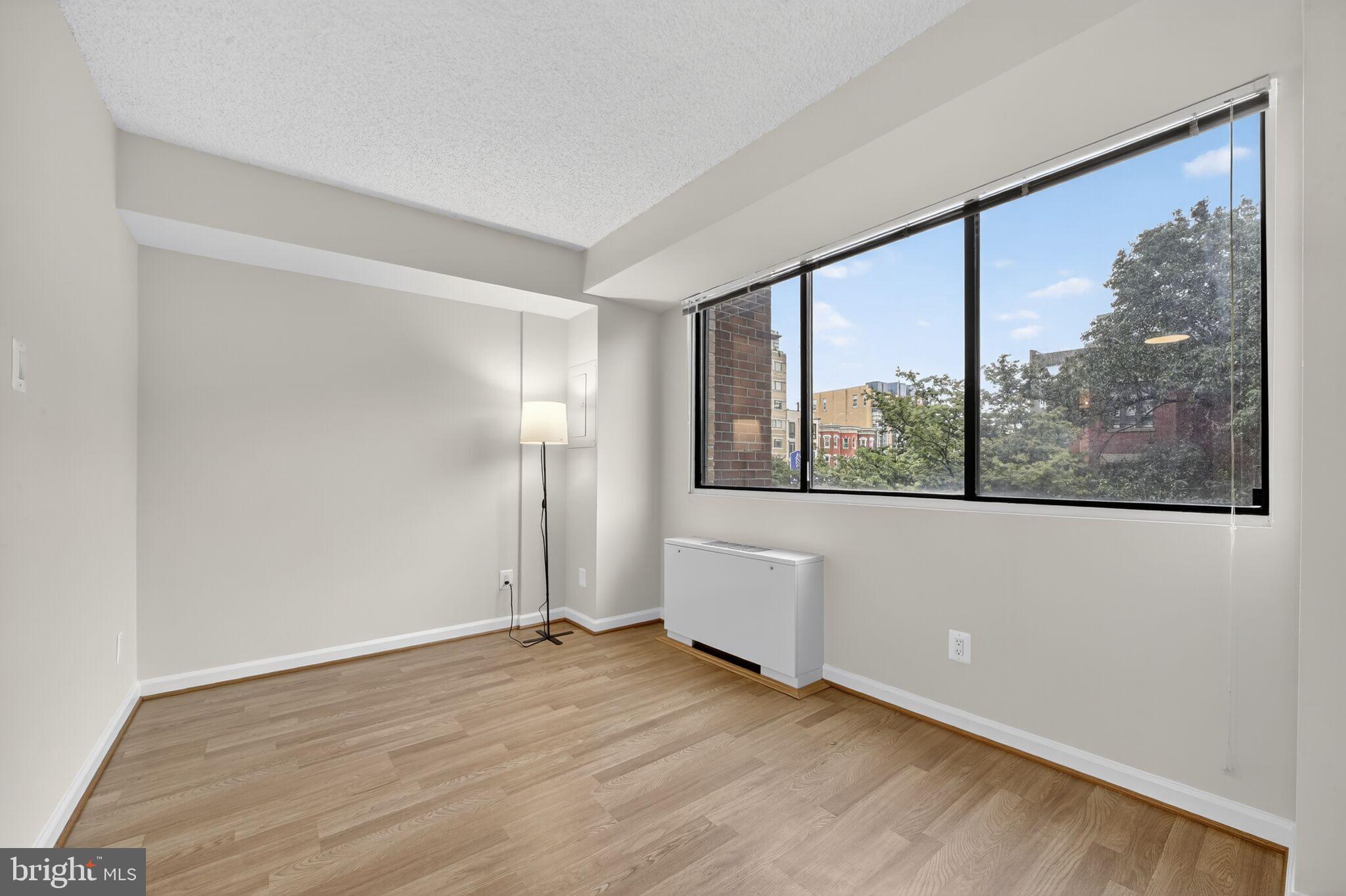 1245 13th Street Northwest, Unit 304 Washington, DC 20005 - Photo 2 of 43 a view of an empty room with wooden floor and a window