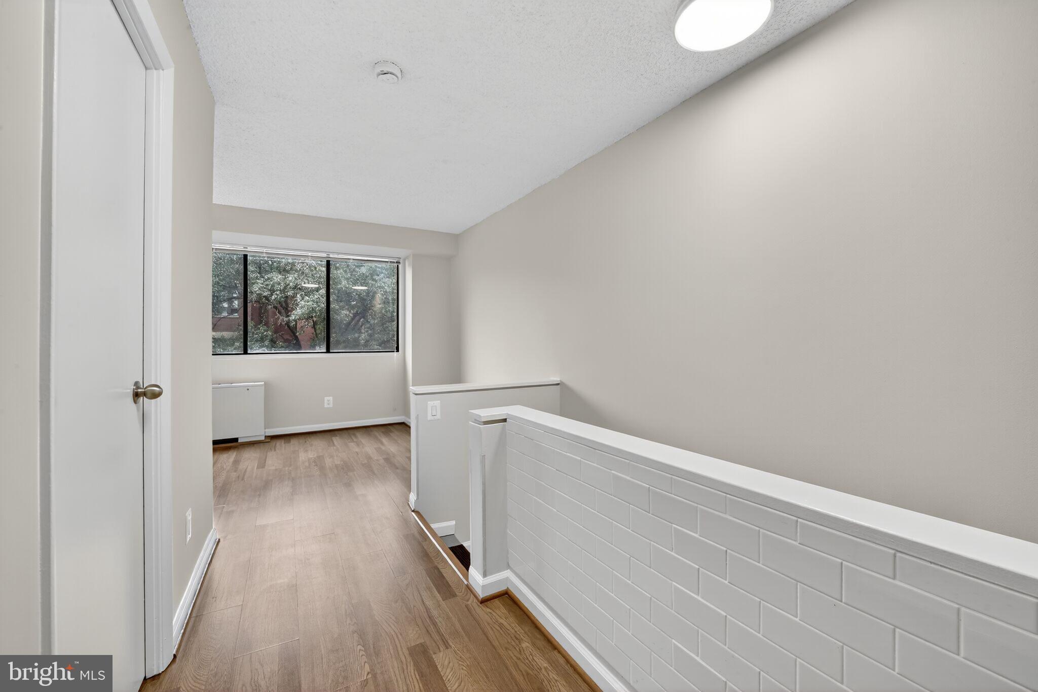 1245 13th Street Northwest, Unit 304 Washington, DC 20005 - Photo 4 of 43 a view of an empty room with wooden floor and a window