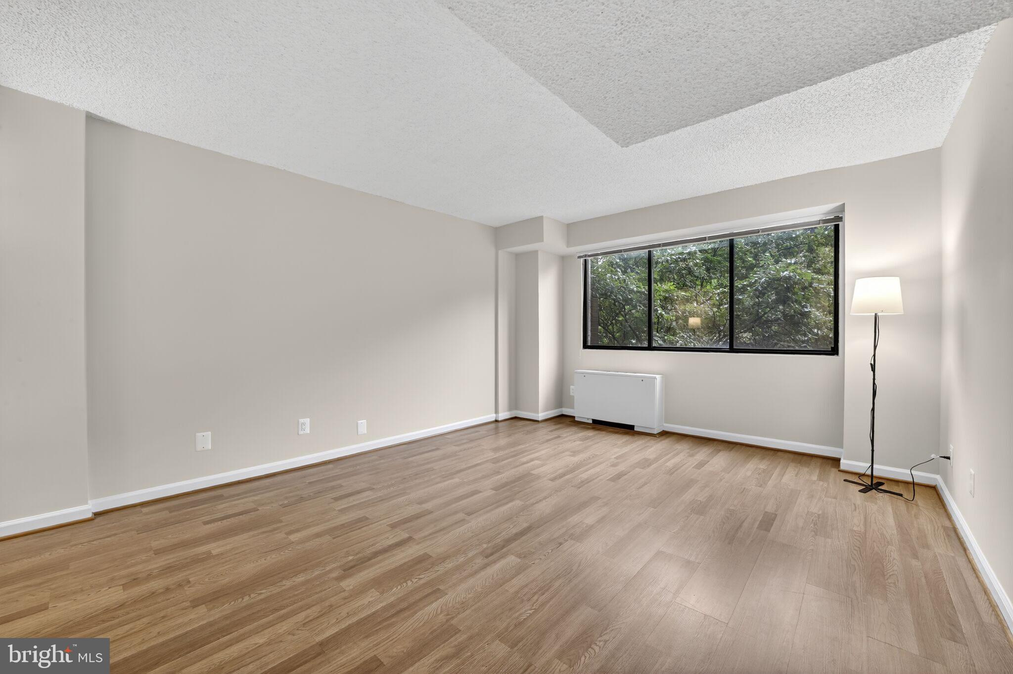 1245 13th Street Northwest, Unit 304 Washington, DC 20005 - Photo 8 of 43 an empty room with wooden floor and windows