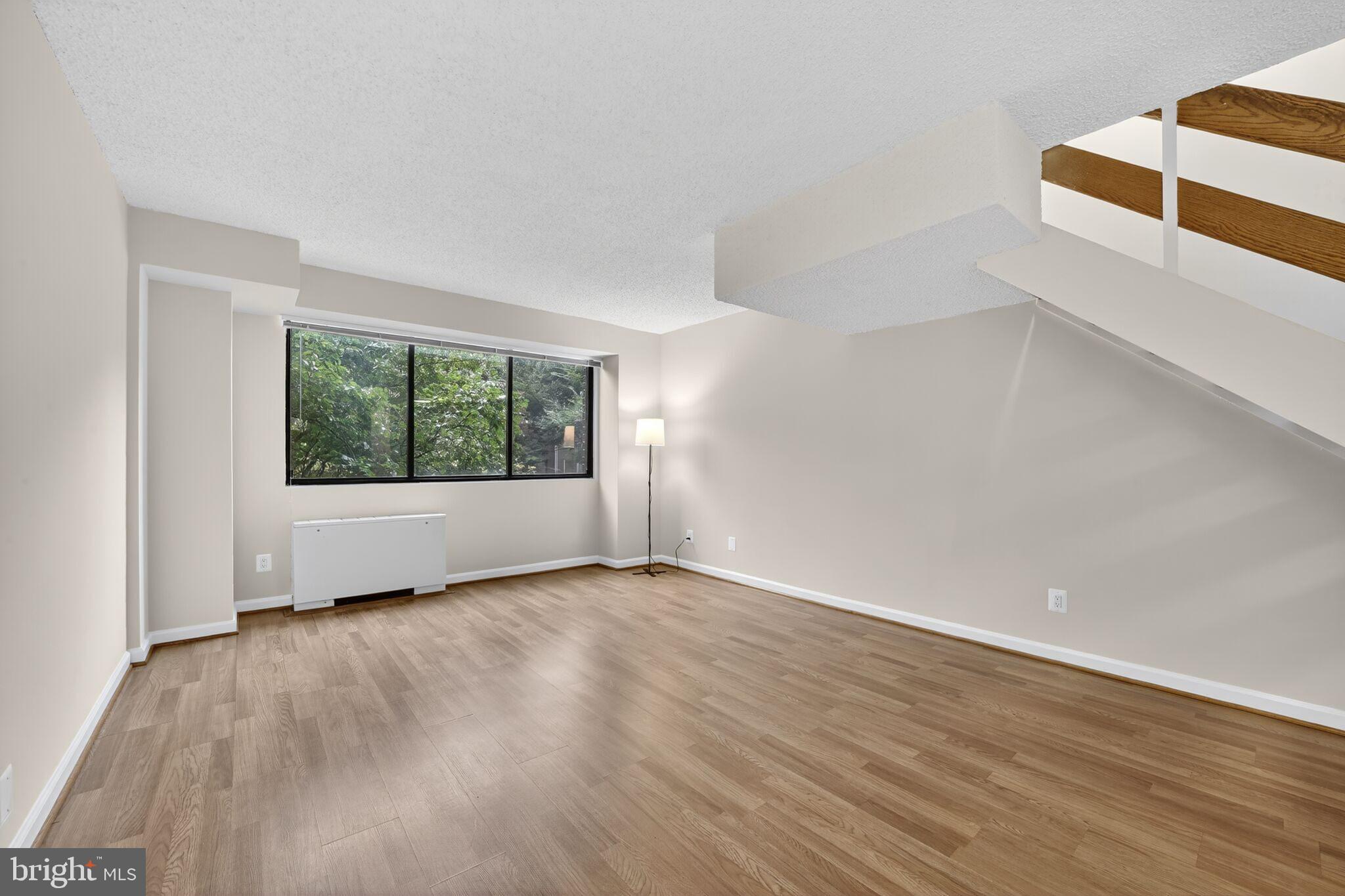 1245 13th Street Northwest, Unit 304 Washington, DC 20005 - Photo 9 of 43 an empty room with wooden floor and windows