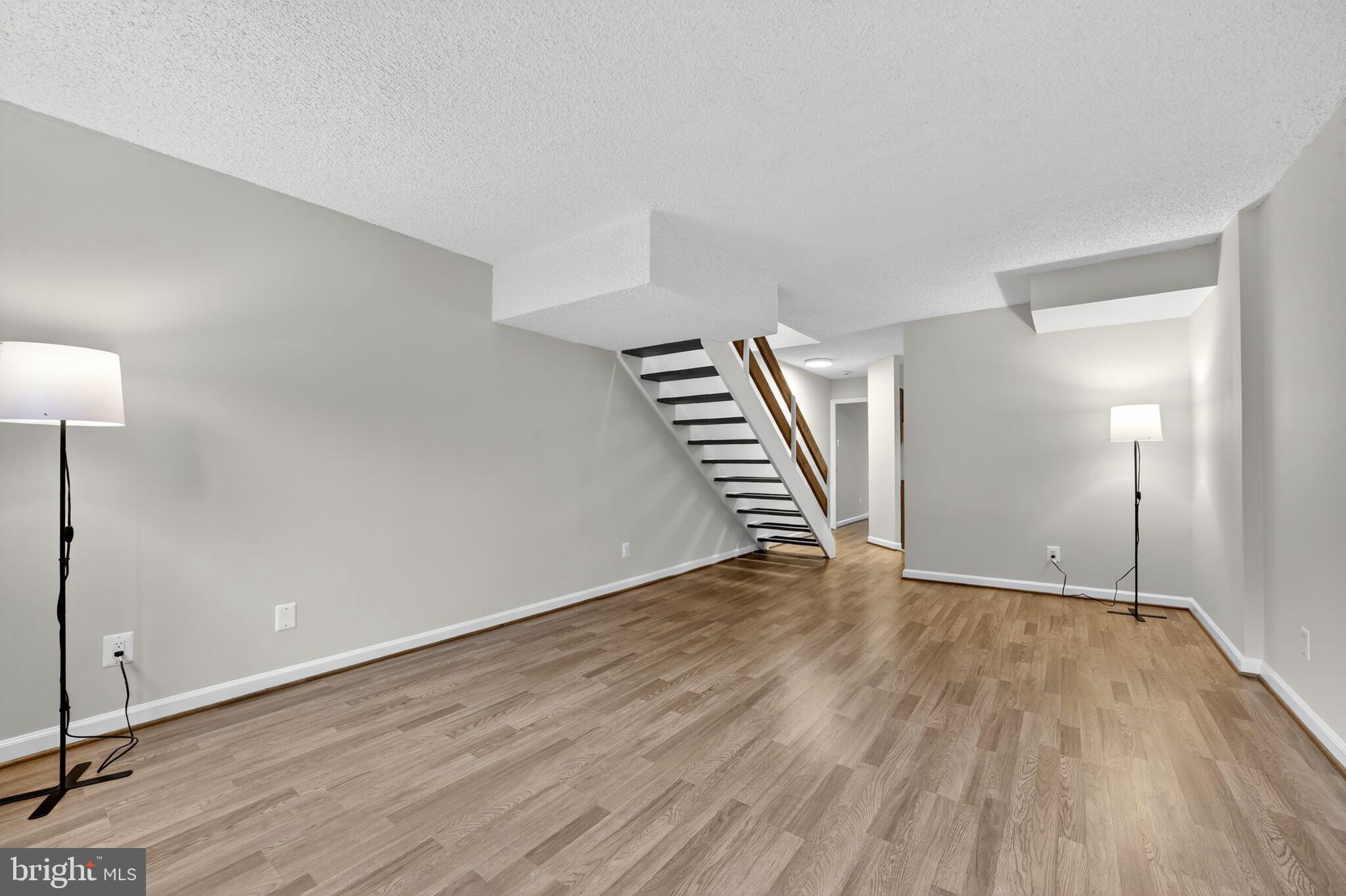 1245 13th Street Northwest, Unit 304 Washington, DC 20005 - Photo 10 of 43 an empty room with wooden floor and stairs