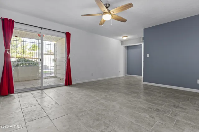 an empty room with closet and a chandelier fan
