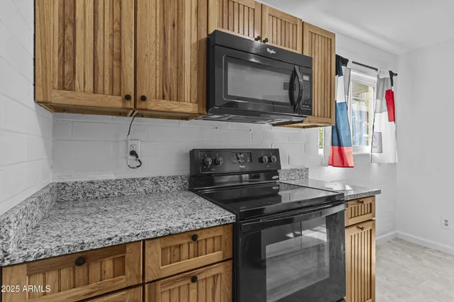 a kitchen with stainless steel appliances granite countertop a stove microwave and cabinets
