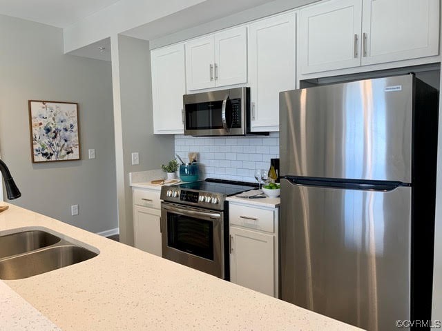 1504 Ewing Park Loop, Unit 203 Midlothian, VA 23113 - Photo 5 of 17 a kitchen with stainless steel appliances granite countertop a refrigerator a stove a sink and white cabinets