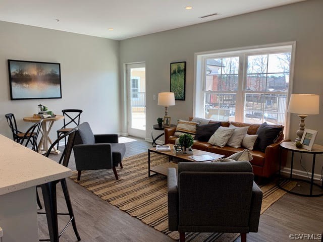 1504 Ewing Park Loop, Unit 203 Midlothian, VA 23113 - Photo 7 of 17 a living room with furniture a wooden floor and a large window