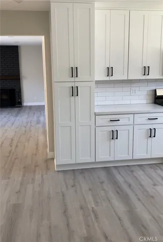 a view of white cabinets and wooden floor