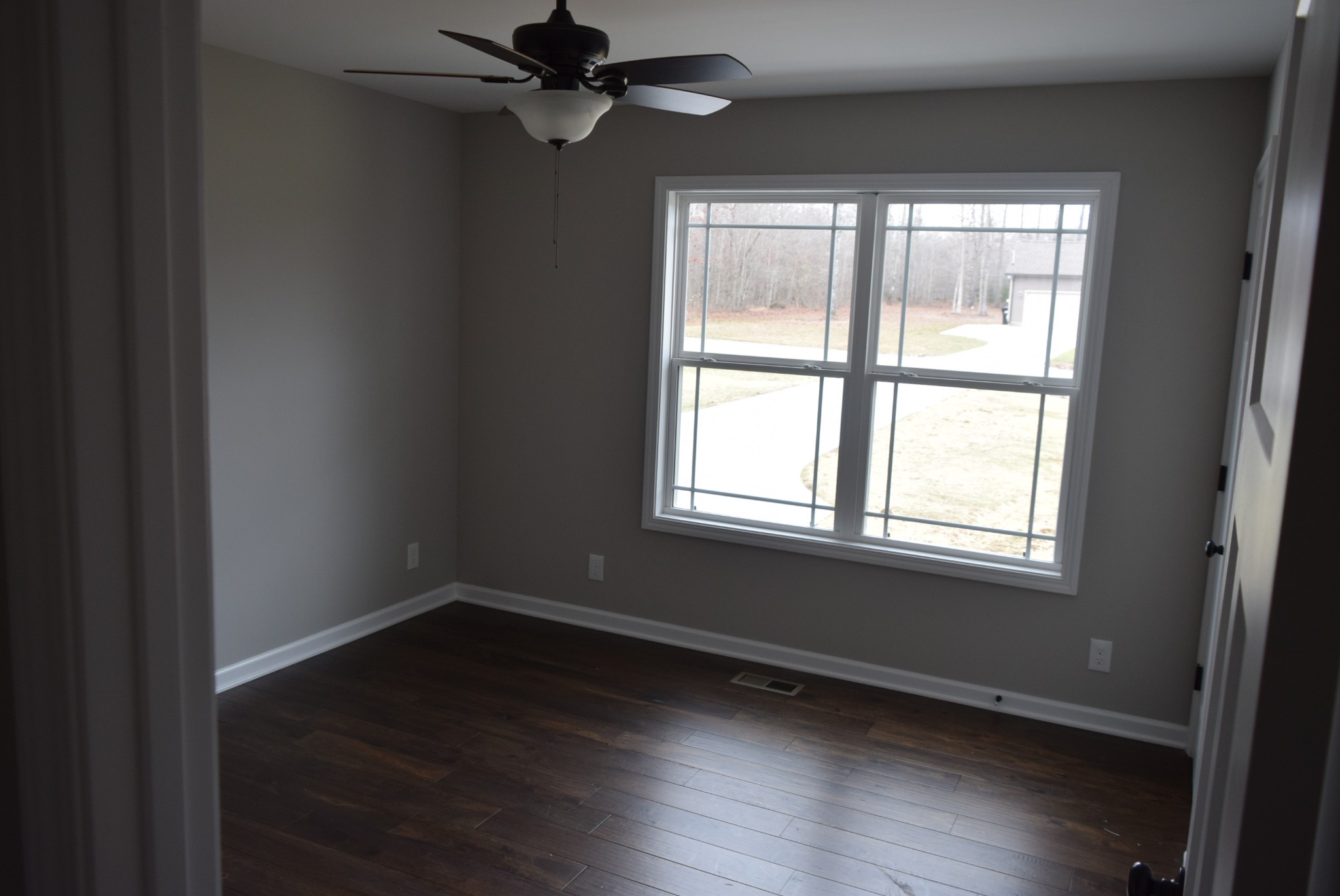 213 Ballard Road Manchester, TN 37355 - Photo 4 of 10 a view of an empty room with wooden floor and a window