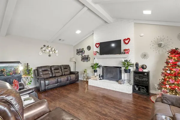 a living room with furniture a fireplace and a flat screen tv