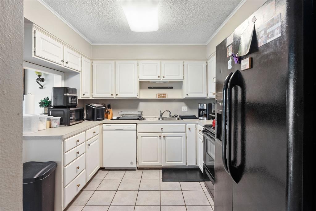 2103 Easy Street Tyler, TX 75703 - Photo 9 of 32 a kitchen with white cabinets and white appliances