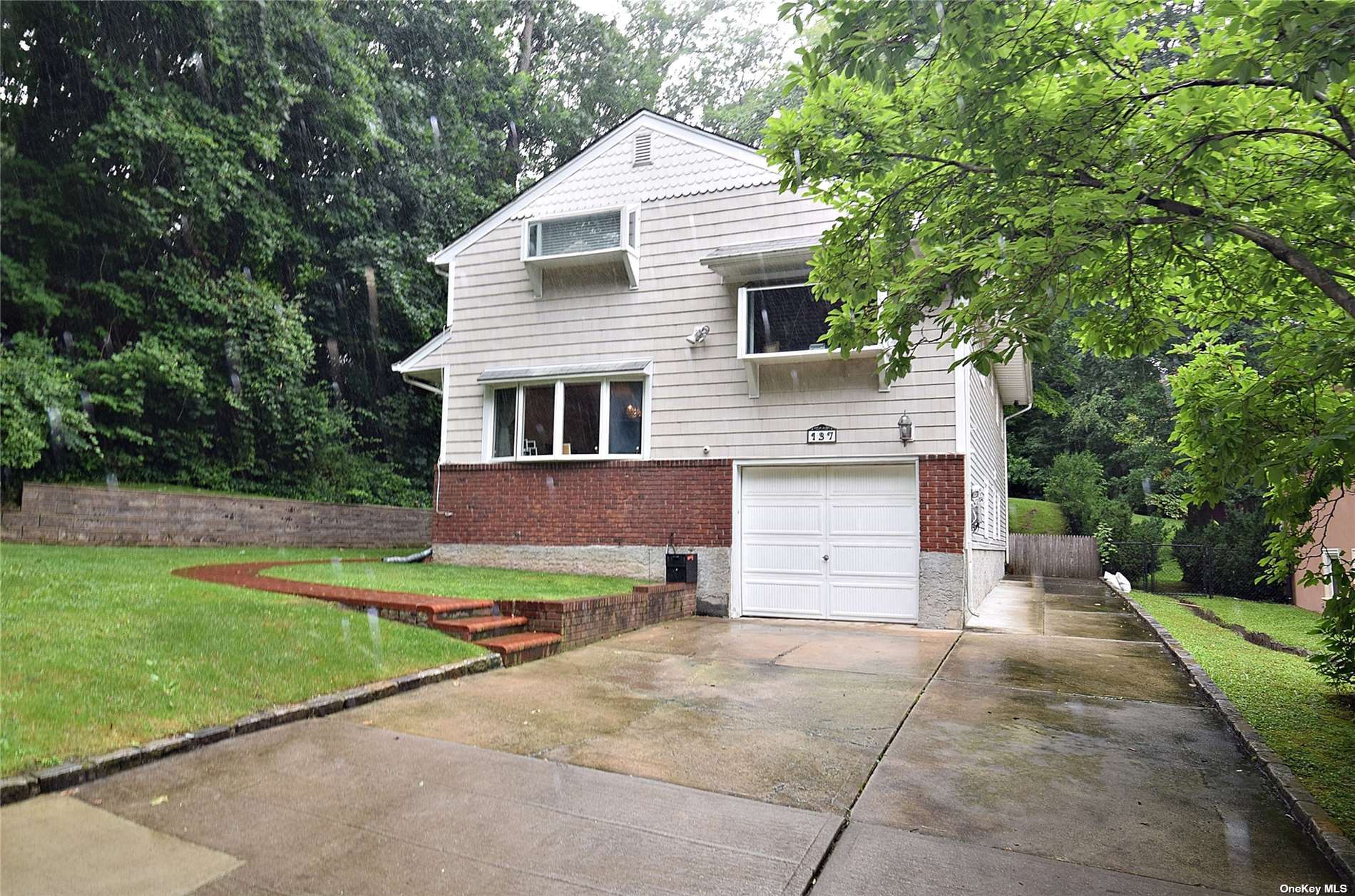 137 Colonial Road Great Neck, NY 11023 - Photo 1 of 1 a front view of a house with a yard and garage