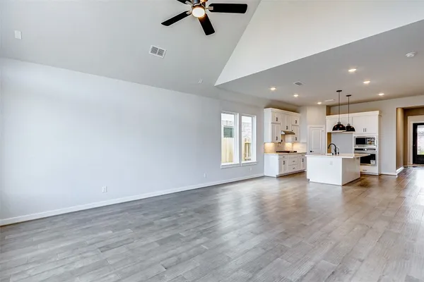 a view of empty room with wooden floor and window