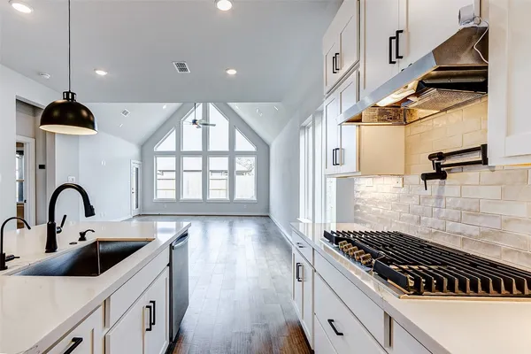 a kitchen with kitchen island a counter space a sink a window and stainless steel appliances