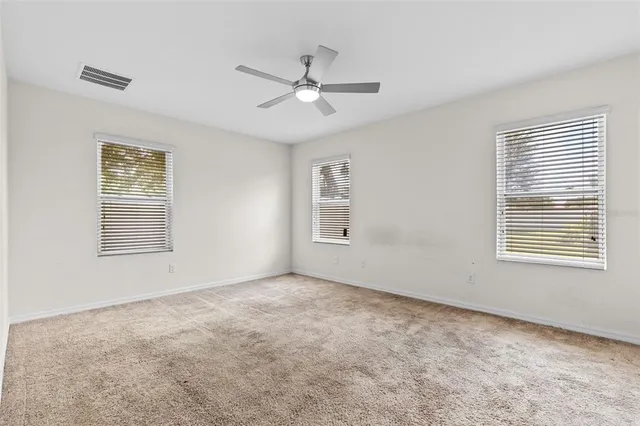 an empty room with closet and ceiling fan