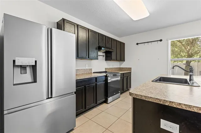 a kitchen with stainless steel appliances granite countertop a sink and a stove