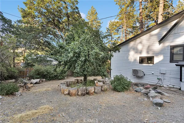 a view of a house with backyard and wooden fence
