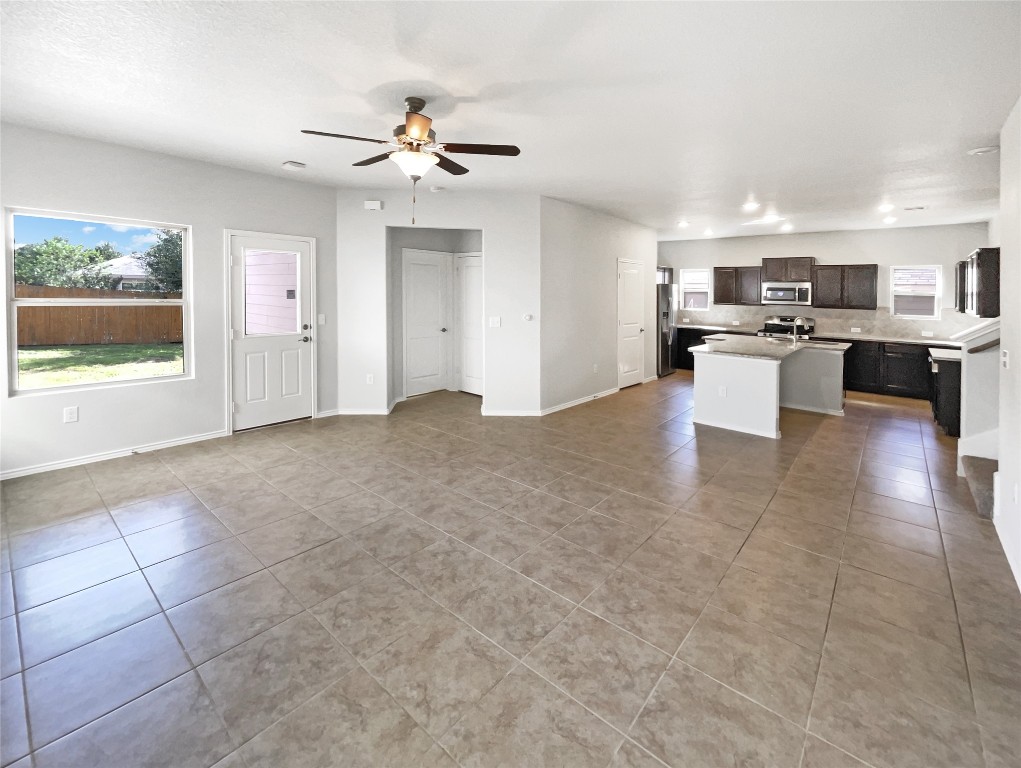 5709 Southerner Way Austin, TX 78747 - Photo 13 of 26 Unfurnished living room featuring light tile patterned floors, ceiling fan, and recessed lighting