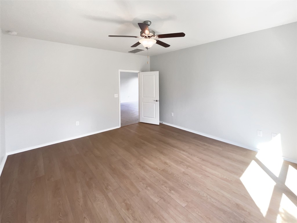 5709 Southerner Way Austin, TX 78747 - Photo 16 of 26 Empty room featuring light wood finished floors and a ceiling fan