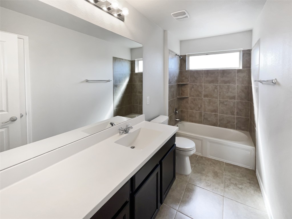 5709 Southerner Way Austin, TX 78747 - Photo 18 of 26 Full bathroom featuring shower / bath combination, vanity, and light tile patterned floors