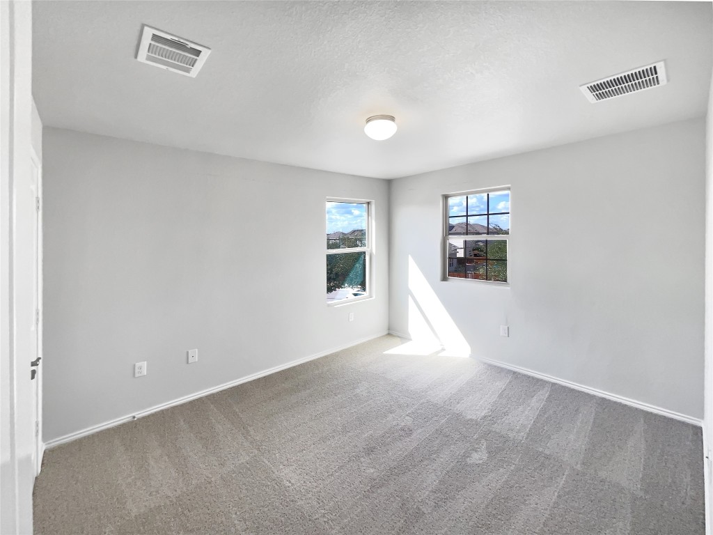 5709 Southerner Way Austin, TX 78747 - Photo 19 of 26 Carpeted spare room featuring a textured ceiling and baseboards