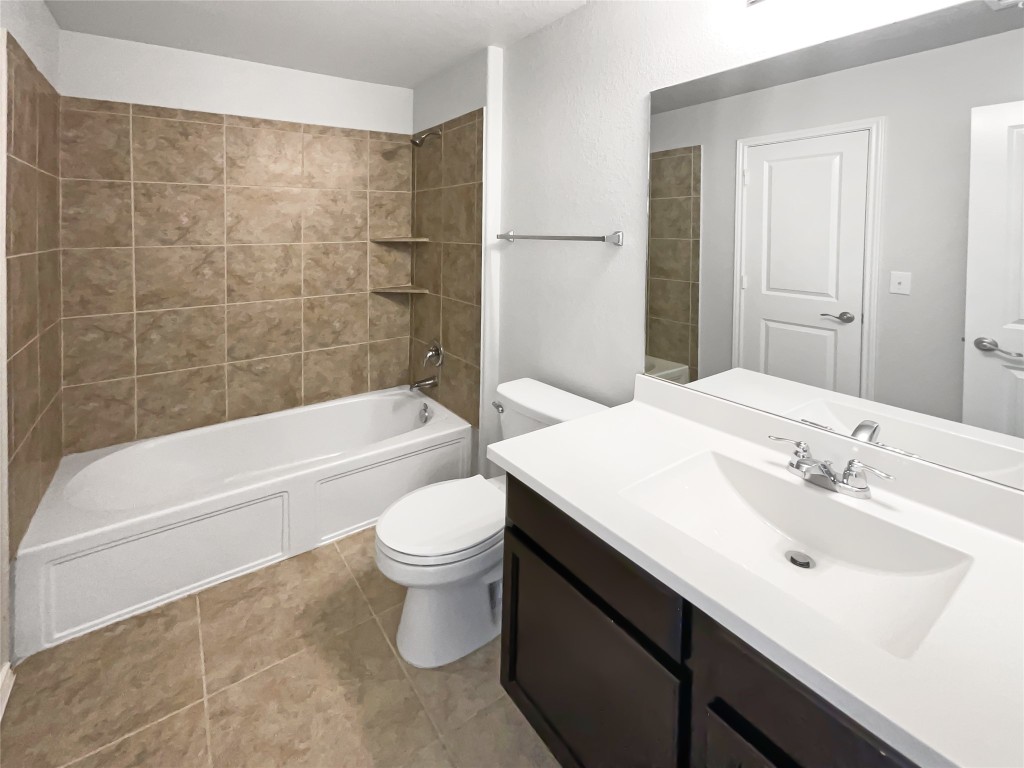 5709 Southerner Way Austin, TX 78747 - Photo 21 of 26 Full bathroom featuring washtub / shower combination, vanity, and light tile patterned floors