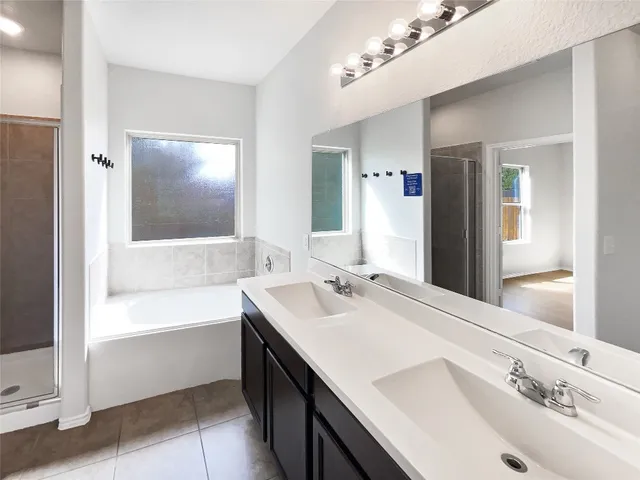 a bathroom with a tub sink and mirror