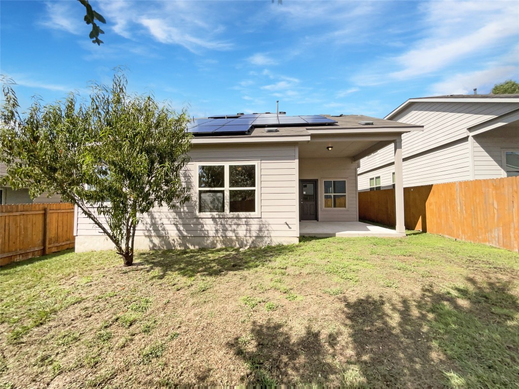 5709 Southerner Way Austin, TX 78747 - Photo 8 of 26 Back of property with solar panels, a patio, and a fenced backyard
