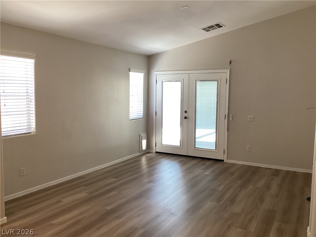 2135 Hidden Ranch Terrace Henderson, NV 89052 - Photo 11 of 27 A living space offers a blend of style and practicality with wood-look flooring and a vaulted ceiling.