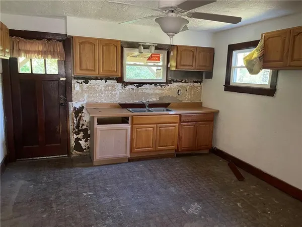 a room with chandelier fan and windows