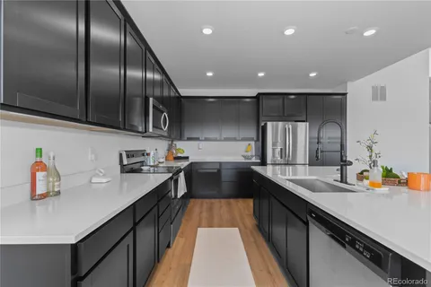 a kitchen with stainless steel appliances granite countertop refrigerator a sink and a stove