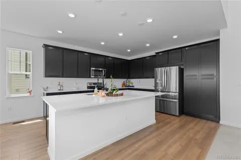 a large kitchen with stainless steel appliances granite countertop a sink a stove a refrigerator and cabinets