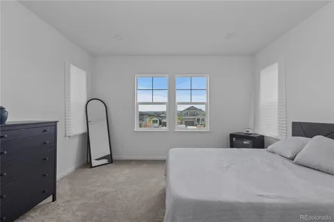 a bedroom with a bed and a large window
