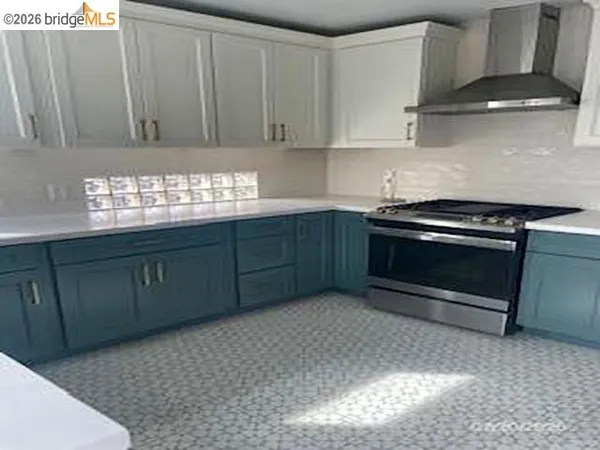 a kitchen with granite countertop a stove top oven sink and cabinets