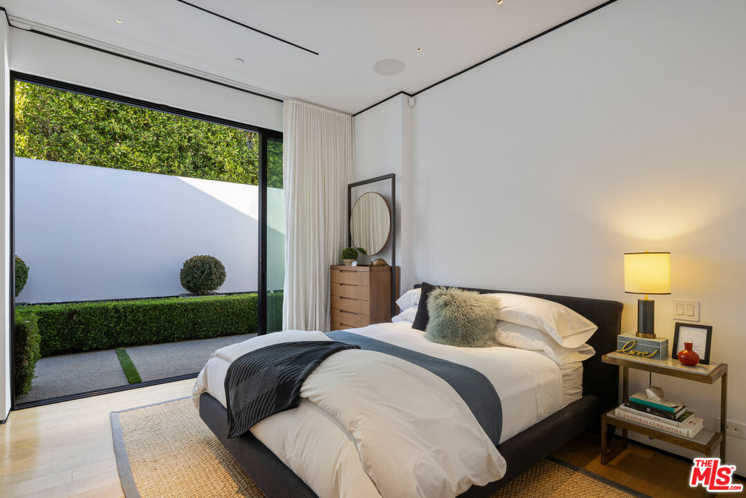 1877 Rising Glen Road Los Angeles, CA 90069 - Photo 13 of 29 a bedroom with a bed lamp and a large window with outer view