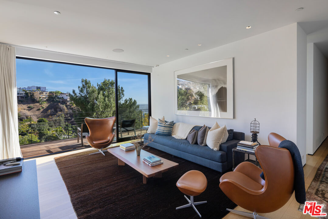 1877 Rising Glen Road Los Angeles, CA 90069 - Photo 17 of 29 a living room with furniture a rug and a large window