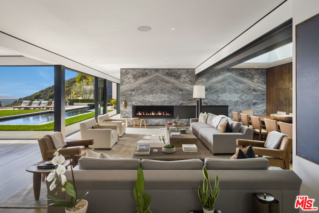 1877 Rising Glen Road Los Angeles, CA 90069 - Photo 5 of 29 a living room with fireplace furniture and a floor to ceiling window