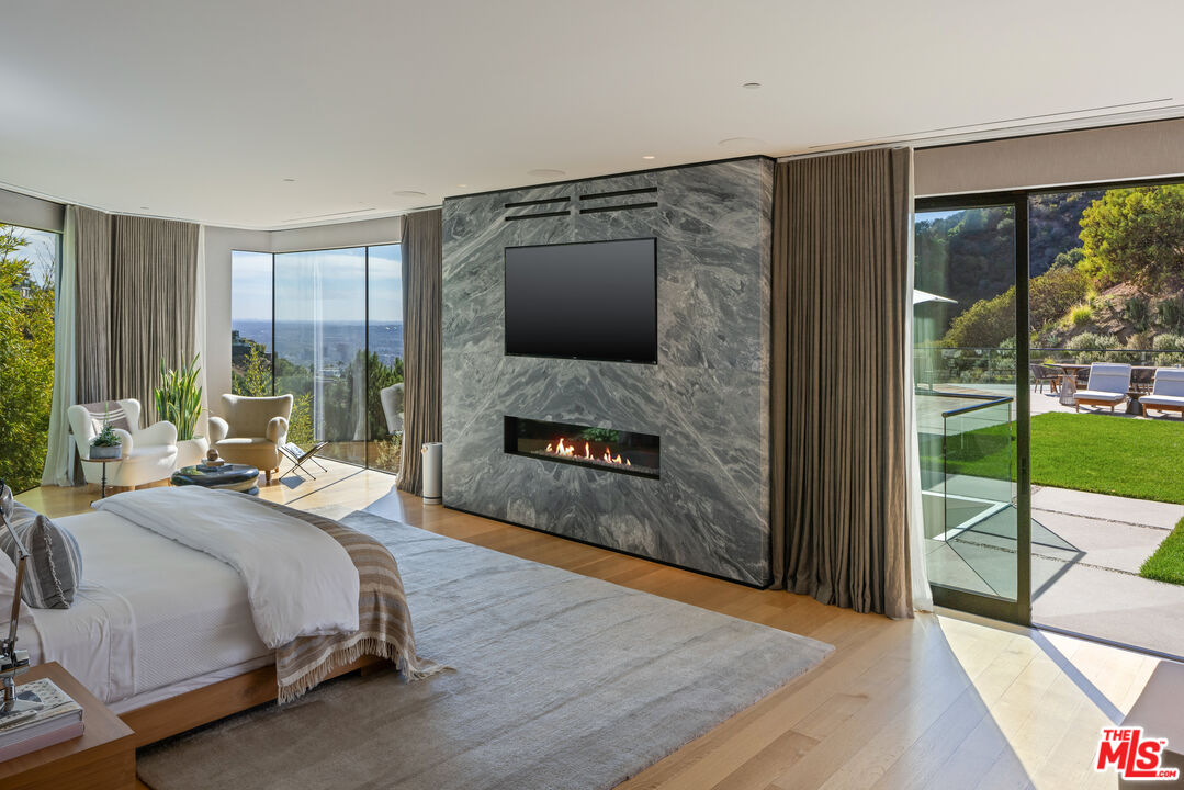 1877 Rising Glen Road Los Angeles, CA 90069 - Photo 8 of 29 a bedroom with a bed and a fireplace