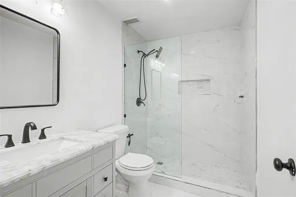 a bathroom with a granite countertop sink toilet and shower