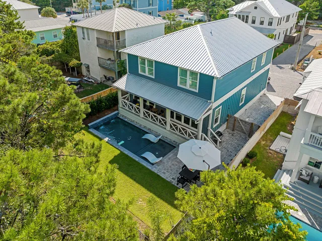 an aerial view of a house with a big yard and large trees