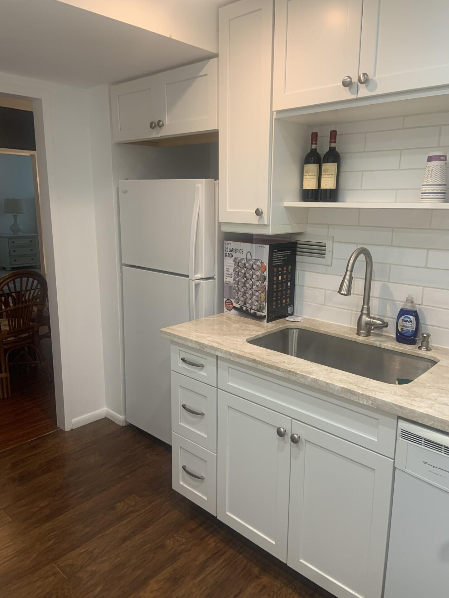 2840 South Ocean Boulevard, Unit 2050 Palm Beach, FL 33480 - Photo 6 of 18 a kitchen with white cabinets and sink