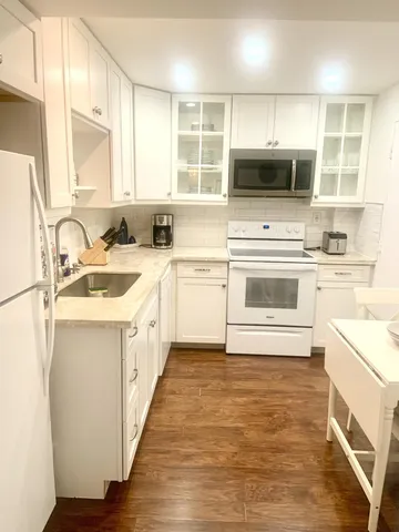 a kitchen with a sink stove microwave and cabinets