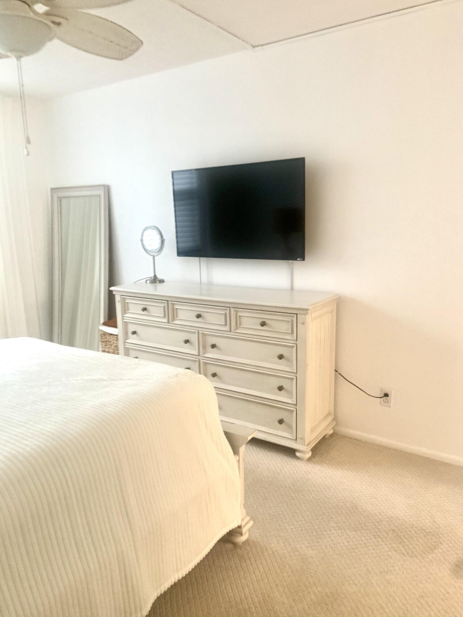 2840 South Ocean Boulevard, Unit 2050 Palm Beach, FL 33480 - Photo 9 of 18 a bedroom with a bed and flat screen tv