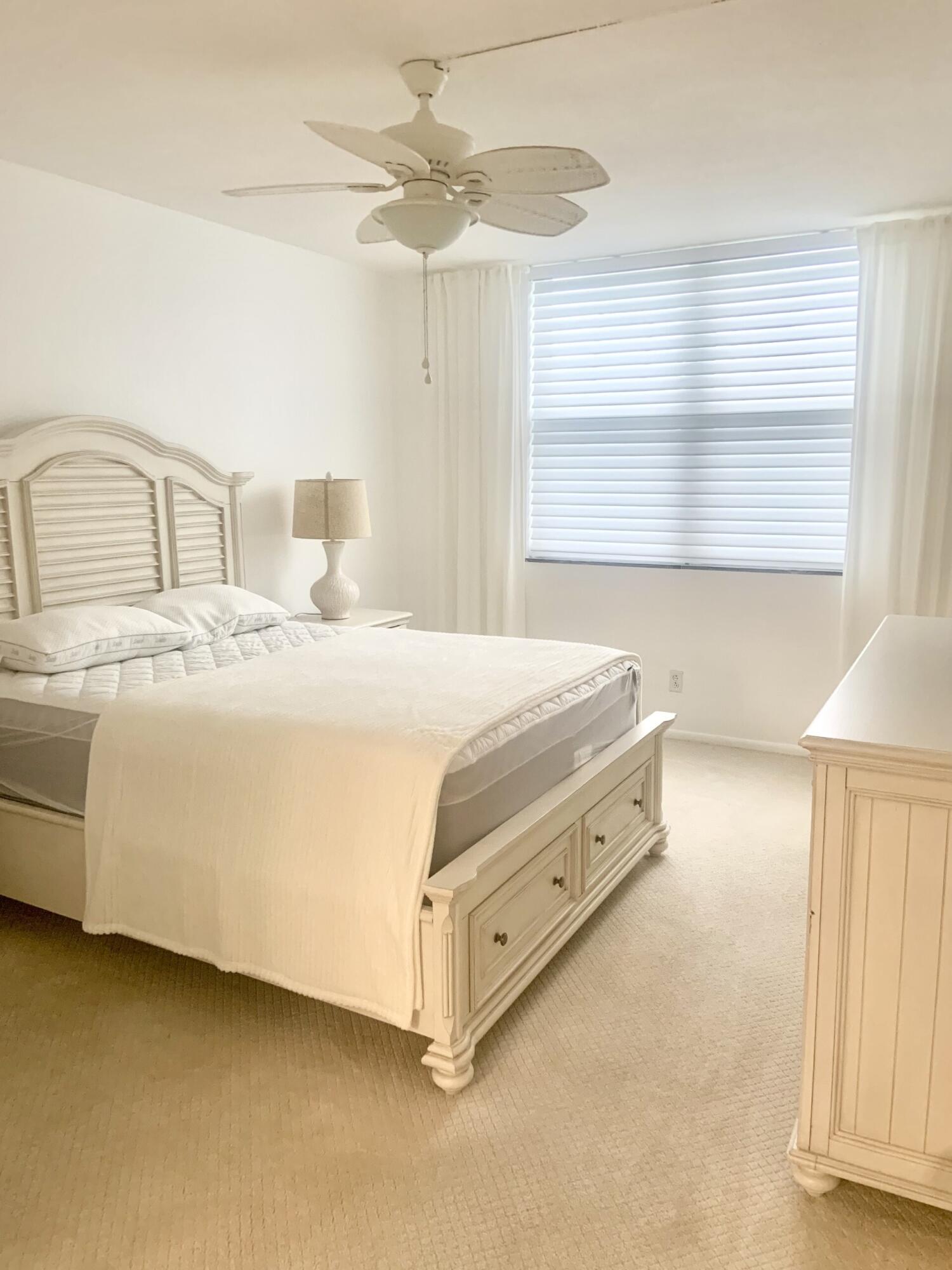 2840 South Ocean Boulevard, Unit 2050 Palm Beach, FL 33480 - Photo 10 of 18 a spacious bedroom with a bed and a chandelier