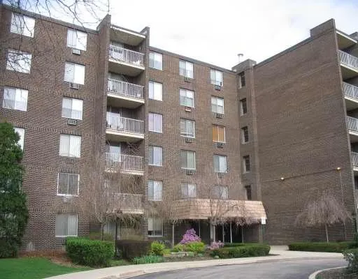 a front view of a building with lot of windows and trees